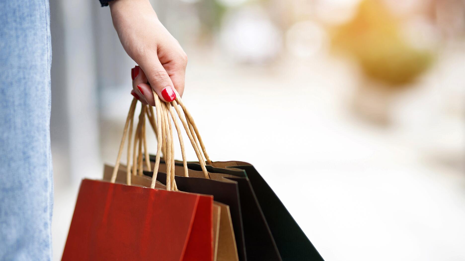 A hand holding shopping bags