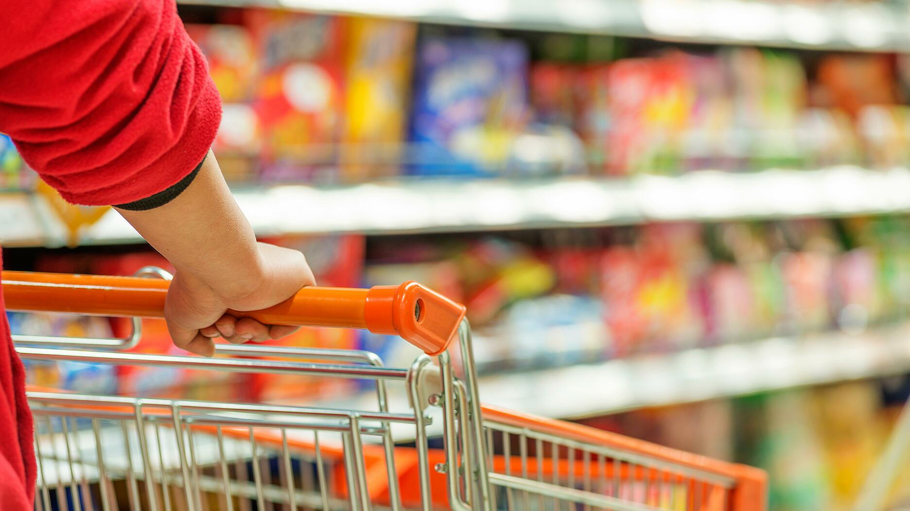 Hands pushing a shopping cart 